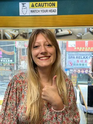 a woman giving a thumbs up in a store at SS Grey Hotel in Kuala Lumpur
