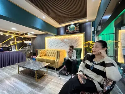 a woman sitting in a chair talking on a cell phone at SS Grey Hotel in Kuala Lumpur