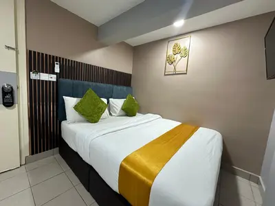 a bedroom with a large bed with green pillows at SS Grey Hotel in Kuala Lumpur