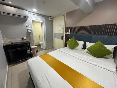 a bedroom with a large bed with green pillows at SS Grey Hotel in Kuala Lumpur