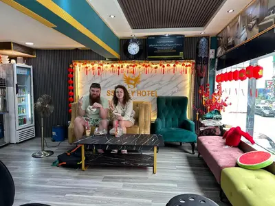 a man and woman sitting on a couch in a living room at SS Grey Hotel in Kuala Lumpur