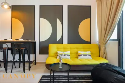 a living room with a yellow couch and a table at The Luxe & The Colony, KLCC in Kuala Lumpur