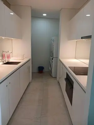 a kitchen with white counters and a washer and dryer at VORTEX STAR KLCc APARTMENT in Kuala Lumpur