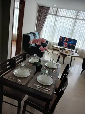 a dining room table with plates and flowers on it at VORTEX STAR KLCc APARTMENT in Kuala Lumpur