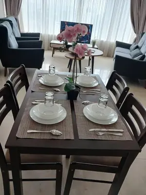 a wooden table with plates and utensils on it at VORTEX STAR KLCc APARTMENT in Kuala Lumpur