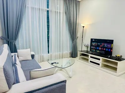 a living room with a couch and a television at Soho Suites KLCC by Angel in Kuala Lumpur