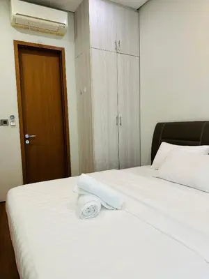 a white bed with a towel on top of it at Soho Suites KLCC by Angel in Kuala Lumpur