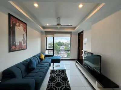 a living room with a blue couch and a flat screen tv at BBHomes at Casa Residency KL in Kuala Lumpur