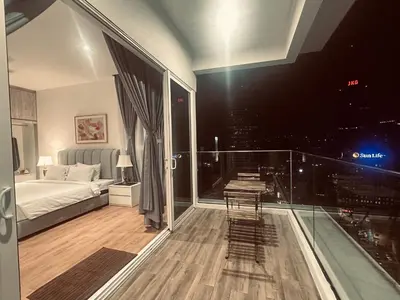 a bedroom with a bed and a glass balcony at Quill Suites KLCC in Kuala Lumpur