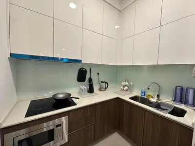 a kitchen with white cabinets and a sink at family suite Laville#velocity maluri by Homeizing in Kuala Lumpur