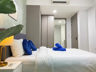 a bedroom with a white bed with blue pillows at Eaton Suites KLCC Kuala Lumpur in Kuala Lumpur