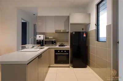 a kitchen with a black refrigerator and a sink at Trion Kuala Lumpur by Five Senses in Kuala Lumpur