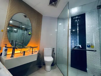 a bathroom with a shower and a toilet and a mirror at Private Jacuzzi Suite - Pertama Residency in Kuala Lumpur