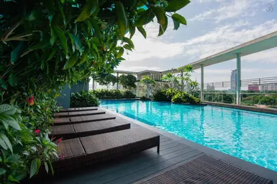 a swimming pool with benches next to a building at Yelloduck Rooms & Apartment @ Casa Residency in Kuala Lumpur