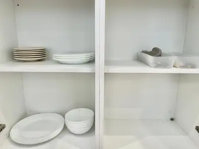 a white pantry with plates and bowls on shelves at Trion KL 10mins to KLCC-Lalaport-Velocity 6 Pax in Kuala Lumpur