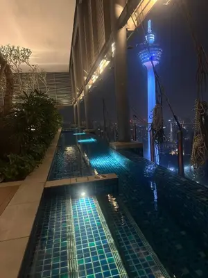 a swimming pool with blue lights on the side of a building at Luxury 2BR KL View, Infinity Pool, Walk to Pavilion and Jalan Alor in Kuala Lumpur
