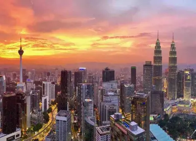 a city skyline with the petronas towers at sunset at Cozy Duplex Studio near Kuala Lumpur next to LRT Train Station in Ampang