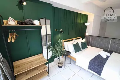 a bedroom with a bed and a green wall at Cozy Duplex Studio near Kuala Lumpur next to LRT Train Station in Ampang