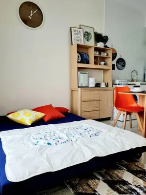 a bedroom with a bed and a table and a kitchen at Best Affordable Homestay, Arte Mont Kiara, KL in Kuala Lumpur