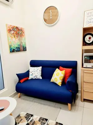 a blue couch with colorful pillows in a living room at Best Affordable Homestay, Arte Mont Kiara, KL in Kuala Lumpur