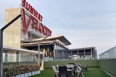 a building with tables and chairs in front of it at Cozy KL Sunway Velocity Residence for 1-5pax connected to MRT & Malls in Kuala Lumpur