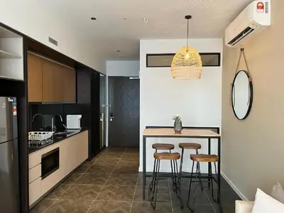 a kitchen with a table and stools in a room at Luxury Apartment at Scarletz Suites Kuala Lumpur in Kuala Lumpur
