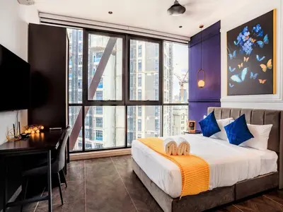 a bedroom with a bed with a desk and a large window at Luxury Apartment at Scarletz Suites Kuala Lumpur in Kuala Lumpur