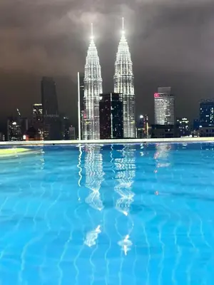 a swimming pool with a city skyline at night at The Luxe Infinitum Sky pol KLCC in Kuala Lumpur