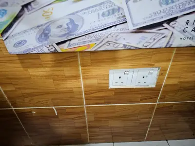 a pile of dollar bills on a wooden wall at 24Seven Guesthouse in Kuala Lumpur