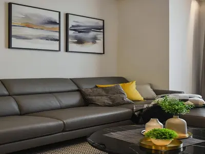 a living room with a brown couch and a table at Kuala Lumpur Apartment at Opus Residence Near China Town and 118 Tower in Kuala Lumpur