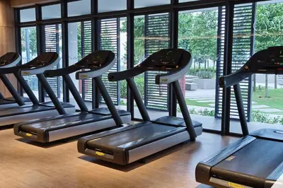 a row of treadmills in a gym with windows at M Vertica Residences@KL in Kuala Lumpur