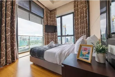 a bedroom with a bed and a large window at Dorsett Residence Kuala Lumpur \u5e1d\u76db\u516c\u5bd3 Bukit Bintang in Kuala Lumpur