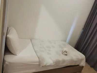 a small bed with a white blanket on it at Arte plus by 2BR sweet home in Kuala Lumpur