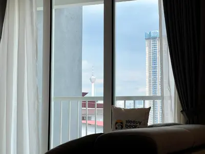 a couch sitting in front of a large window at Court 28 Residence KL Suites 2 Bedroom Apartment by Sleepy Bear in Kuala Lumpur