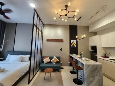 a bedroom with a bed and a desk and a kitchen at Chambers Residences Suites KLCC in Kuala Lumpur
