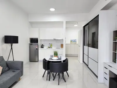 a kitchen and living room with a table and a couch at Chambers Residences Suites KLCC in Kuala Lumpur