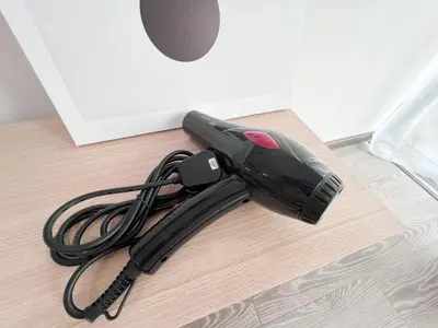 a black corded vacuum sitting on the floor at Maison Signature Suites in Kuala Lumpur