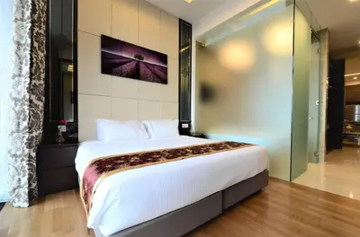 a bedroom with a large bed in a room at The Dorsett Service Suites Bukit Bintang Kuala Lumpur in Kuala Lumpur