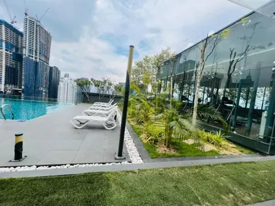 a pool with lounge chairs on the side of a building at The Dorsett Service Suites Bukit Bintang Kuala Lumpur in Kuala Lumpur