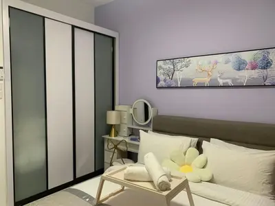 a bedroom with a bed with a chair and a painting at Corner KL Pool View RC Residence with High Internet Speed 500Mbps in Kuala Lumpur