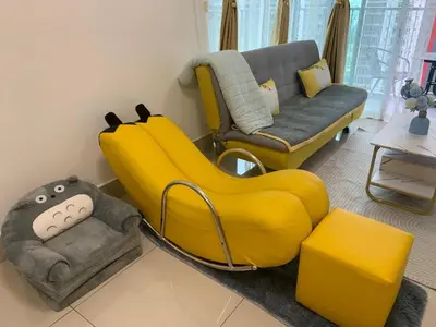 a living room with a large yellow couch at Corner KL Pool View RC Residence with High Internet Speed 500Mbps in Kuala Lumpur
