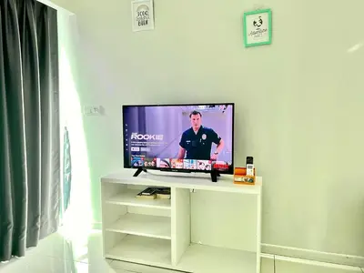 a flat screen tv sitting on a white stand in a room at Summer suites victory house in Kuala Lumpur