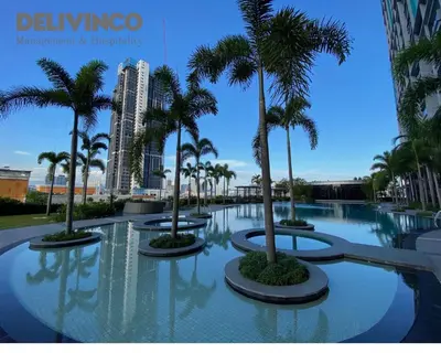 a pool with palm trees in a resort at Trion - KL - 2BR - 6pax - 15min to KLCC & TRX in Kuala Lumpur
