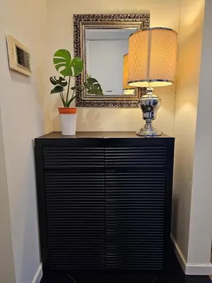 a lamp on a black dresser in front of a mirror at Luxurious Apartment St Mary Residences Resort Style in Kuala Lumpur