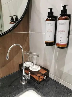 a sink with two bottles of soap and a mirror at Mercure Kuala Lumpur Trion in Kuala Lumpur