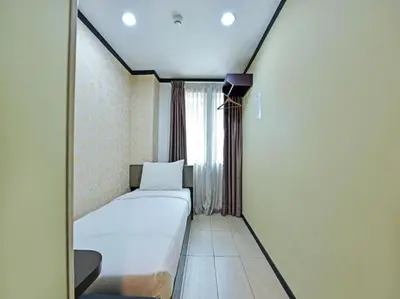 a small bedroom with a bed and a window at One Enigma Hotel in Kuala Lumpur