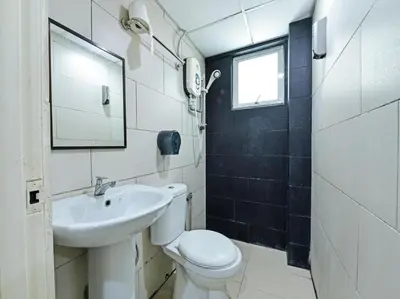 a bathroom with a white toilet and a sink at One Enigma Hotel in Kuala Lumpur