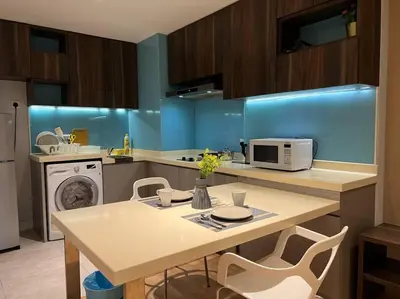 a kitchen with a table with chairs and a microwave at D'Majestic Kuala Lumpur By Luxe Home in Kuala Lumpur