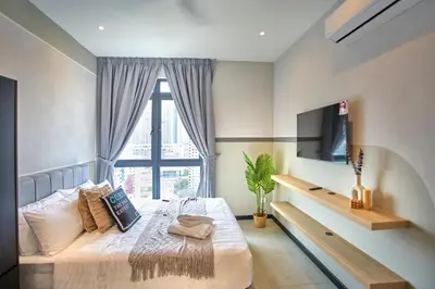 a bedroom with a bed and a tv and a window at Neu Suites Ampang near LRT Jelatek in Kuala Lumpur