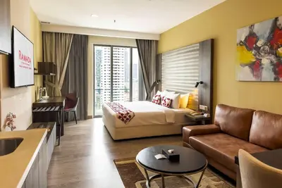 a hotel room with a bed and a couch at Ramada Suites by Wyndham Kuala Lumpur City Centre in Kuala Lumpur